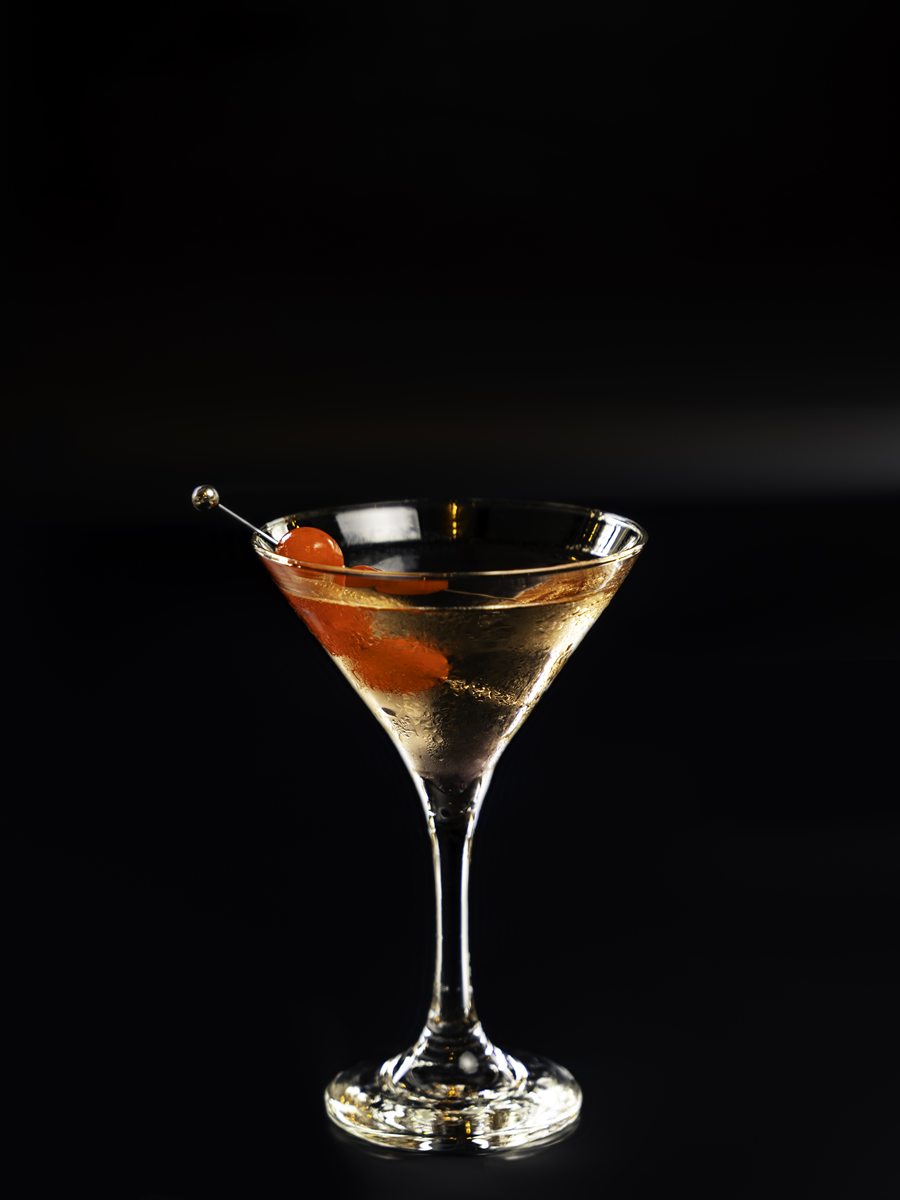 A chilled martini with a cherry garnish at Mina's Table